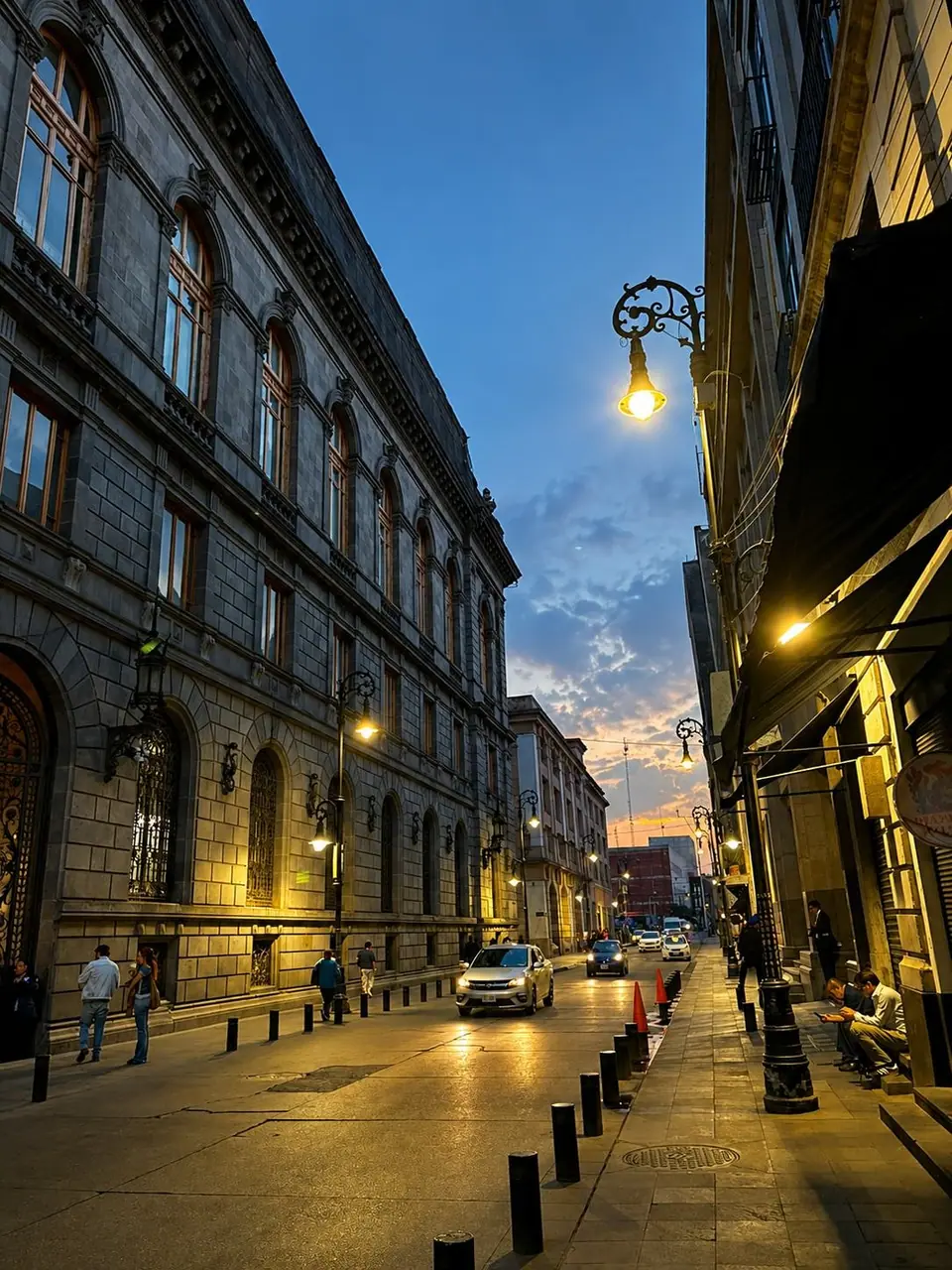 Calle del centro histórico al anochecer, con las farolas encendidas